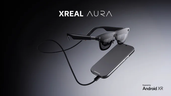 Image of "XREAL AURA," showing a pair of sleek black smart glasses connected via a cable to a smartphone-like computing unit, floating against a dark background with the text "Powered by Android XR."