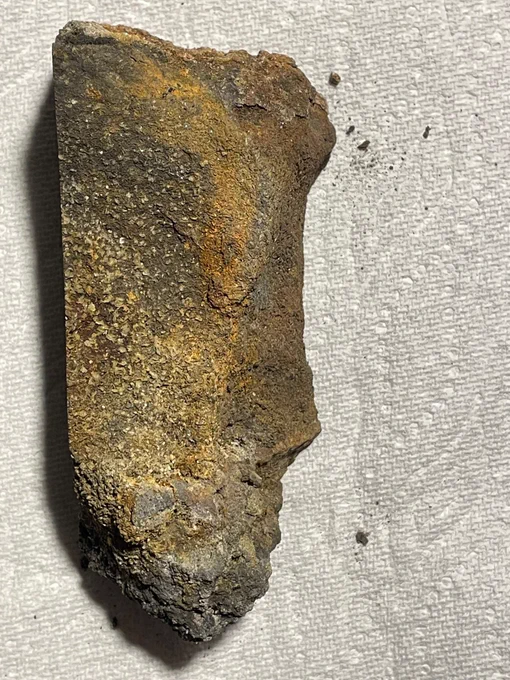 A close-up photo of a rough, rectangular polymetallic sulfide deposit with brown, gray, and yellow layers throughout the textured surface. This polymetallic sulfide deposit was found in the Escanaba Trough in the Gorda Ridge system. Photo Credit: Dr. Paul Knorr, BOEM. 