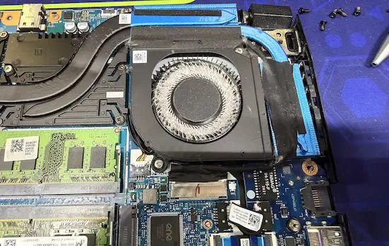 Dust‑clogged laptop cooling fan causing overheating and slow performance, highlighting a common issue fixed with internal cleaning and maintenance.