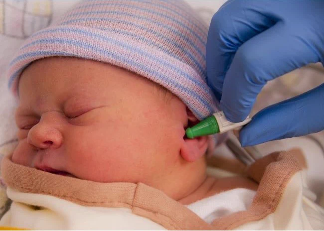 Newborn undergoing hearing screening.