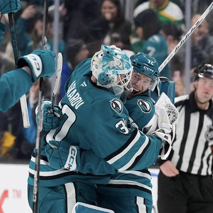 Yaroslav Askarov hugging William Eklund on the ice in the Sharks' teal jersey 