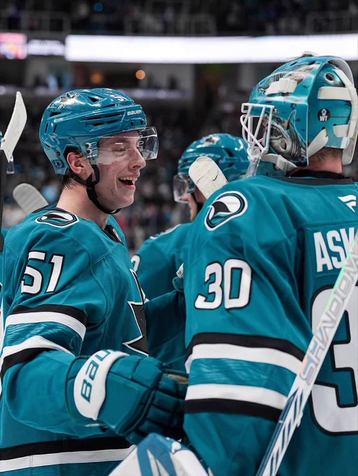 Collin Graf congratulating Yaroslav Askarov on the ice in the Sharks' teal jersey 