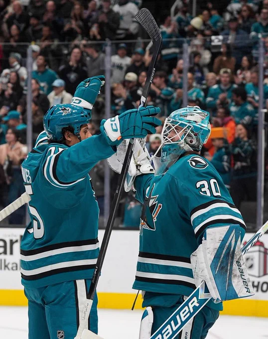 Ryan Reaves congratulating Yaroslav Askarov on the ice in the Sharks' teal jersey