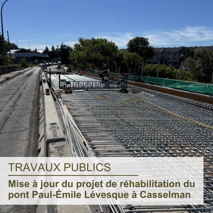 Le pont Paul-Émile Lévesque avec un travailleur dessus qui travaille sur la réhabilitation du pont, avec un ciel bleu, quelques nuages, des bâtiments et des arbres en arrière-plan; le texte superposé en bas à gauche indique « Travaux publics, Mise à jour du projet de réhabilitation du pont Paul-Émile Lévesque à Casselman »