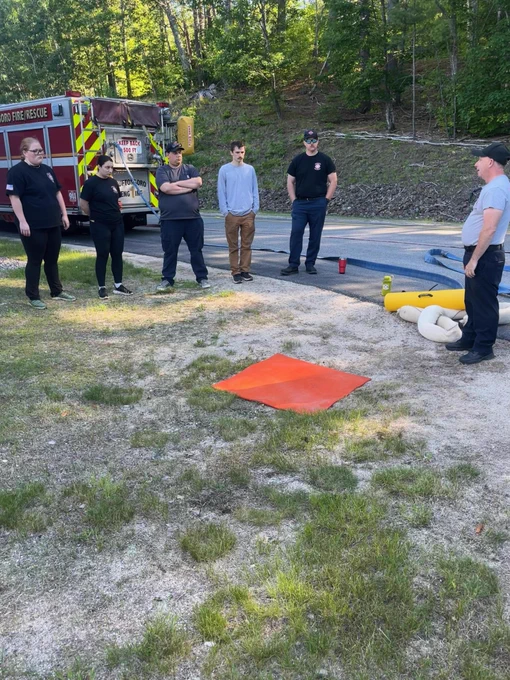 Tuftonboro HazMat Ops class is outside with a set up for a decontamination simulation for a hazardous materials call.