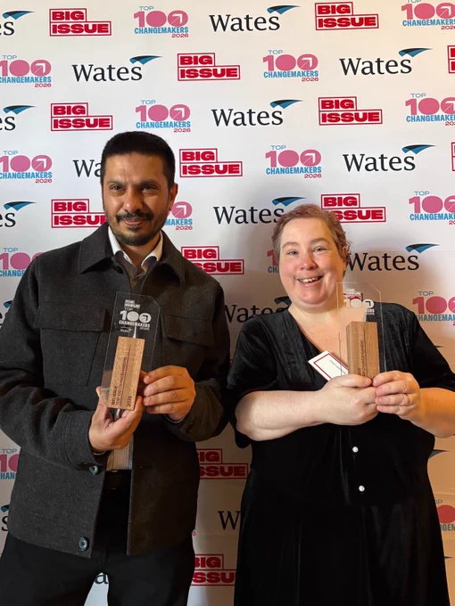 Two award recipients, Ciara and Ismail stand together in front of a step-and-repeat backdrop featuring Big Issue, Wates, and Top 100 Changemakers 2026 logos. Both hold their awards and smile at the camera. Text on the image congratulates Mencap’s Ciara Lawrence, Ismail Kaji, and John Phillips MBE for being named among Big Issue’s 100 Changemakers for 2026.