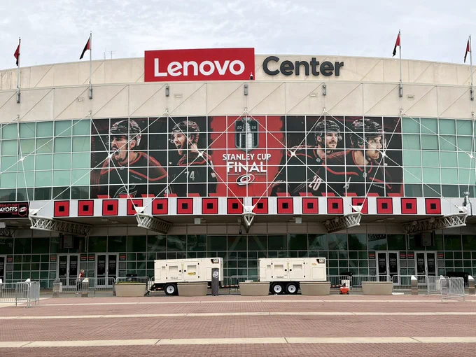 An image of the outside of Lenovo Center, with all 16 warning flags hanging.