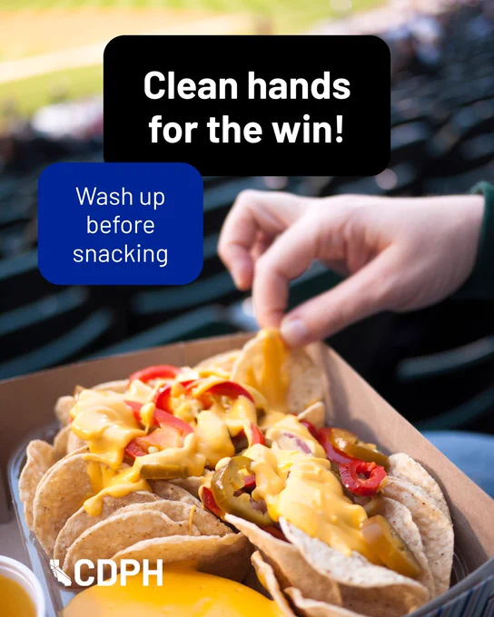 A hand grabbing a chip from a box filled with nachos. "Clean hands for the win! Wash up before snacking"