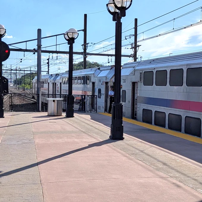 A photo of an NJTransit train with 2 cars extended past the platform.
