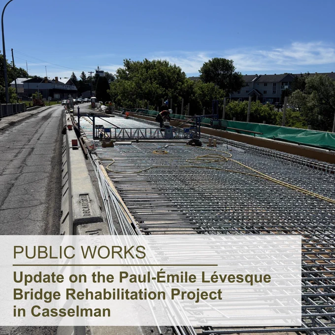 The Paul-Émile Lévesque Bridge with a worker on it working on the bridge rehabilitation, with a blue sky, some clouds, buildings, and trees in the background; the superimposed text in the lower left reads "Public Works, Update on the Paul-Émile Lévesque Bridge Rehabilitation Project in Casselman"