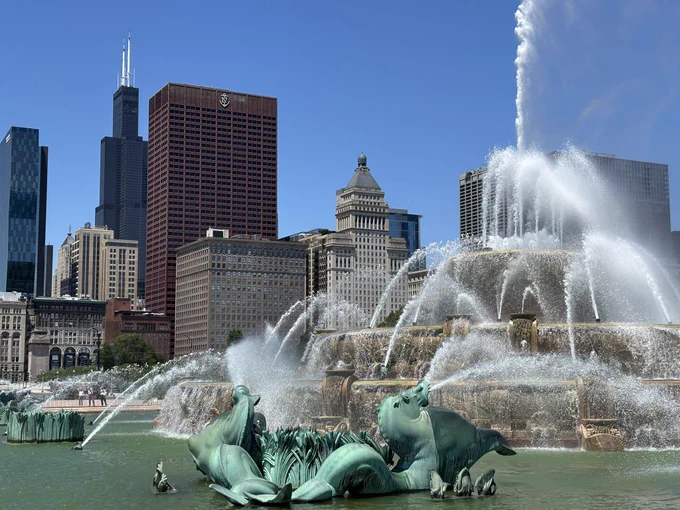 the sears tower rising in the distance behind buckingham fountain