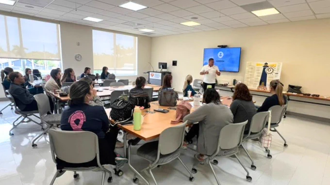 (Photo) A candid photo of John Garcia presenting to a room of 20 people at Nicklaus Children's Hospital. 
