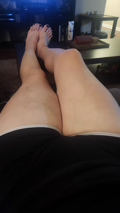 a picture of my thighs and legs, I'm wearing bike shorts and my toes. my bare feet are showing with black nail polish