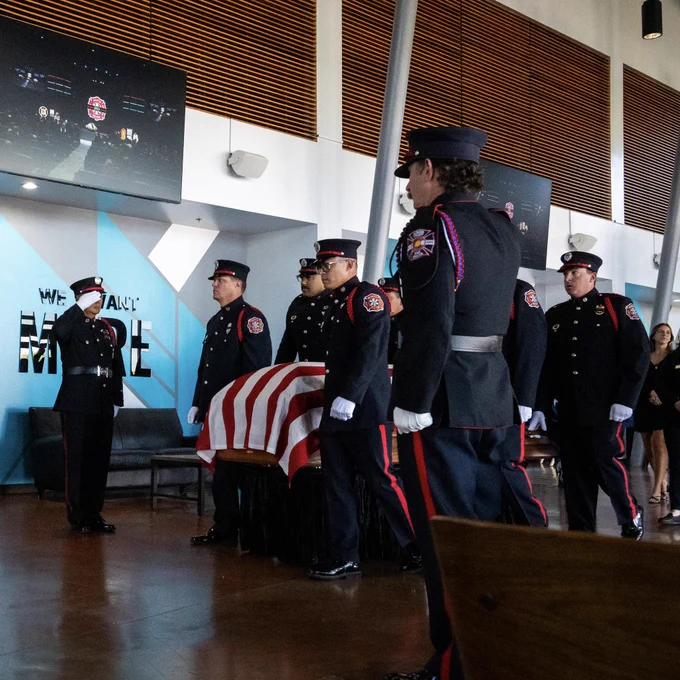 Honor guard escorting a casket into a firefighter funeral