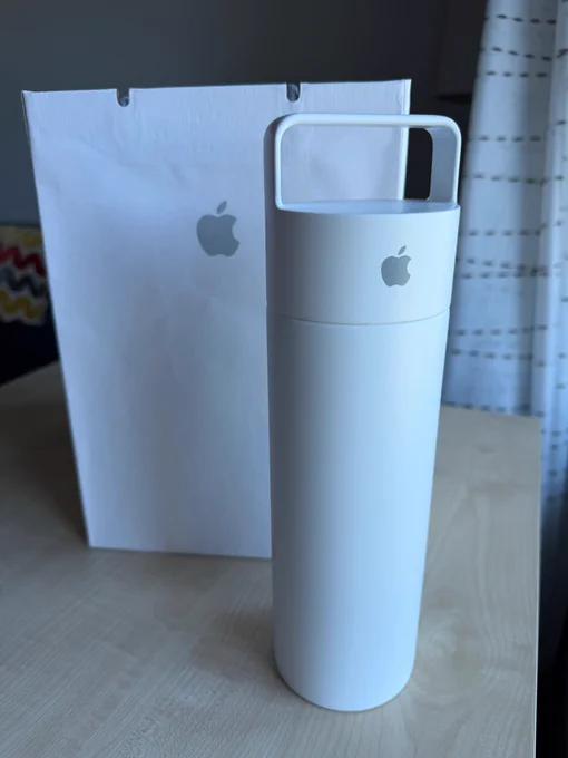 A large, white water bottle with a carry handle and an Apple logo.