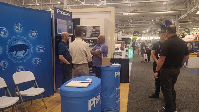 Phason Controls representatives meet with industry professionals at Booth V514 during World Pork Expo 2026. The group discusses Smart Barn Analytics and barn automation solutions.