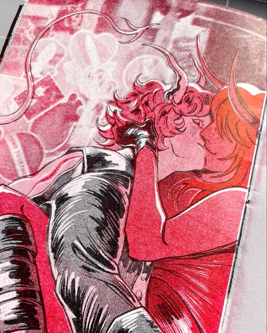 Risograph print in black and red of two characters kissing in front of a wall covered in stickers and flyers. Both characters have horns, and one has a devil tail.