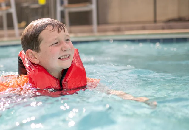 child swimming in life vest