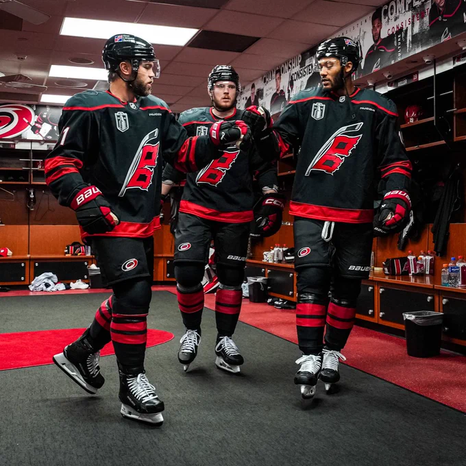 Photo of Taylor Hall and K'Andre Miller fist bumping as they and Alexander Nikishin exit the locker room