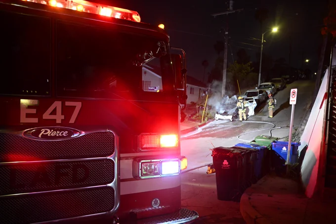 E47 in the foreground with the firefighters in the background making sure the fire is completely out in the engine compartment.