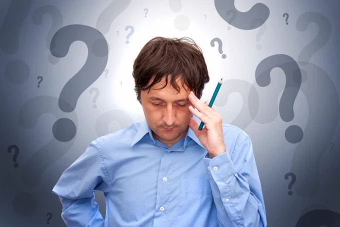 A man is shown in deep thought.  By pressing his left hand to his temple, he gives off a sense of struggling to remember something.  This is reiterated further by the fact he is shown against a background that contains many digital inserted question marks.