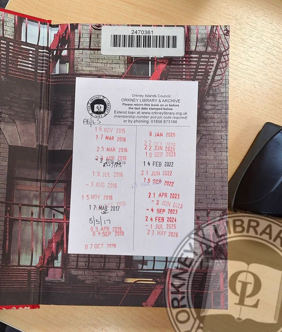 A library book with a date label showing return dates from 2015 to 2026