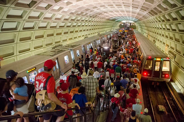 Hundreds of people, many in red baseball jerseys, on a Metro platform after a Washington Nationals game.