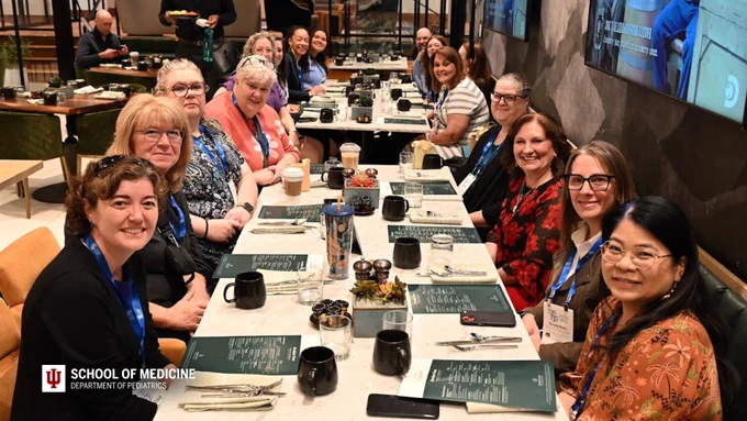 Members of LEAPES are enjoying breakfast at a long table. 