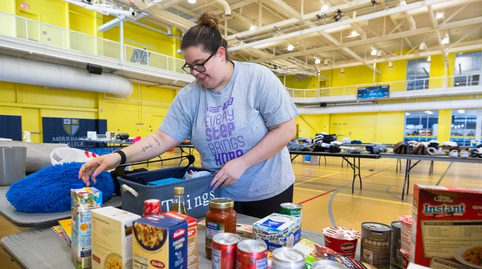 A person organizes donations during Sweeps Week at Merrimack College.