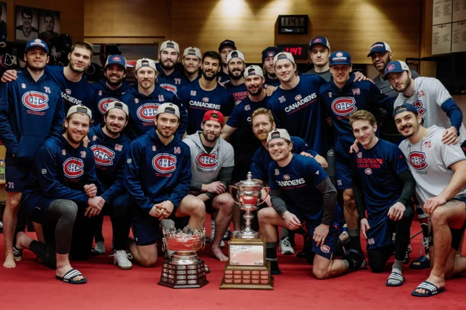 A team photo of the Montreal Canadiens posing with the Selke and Lady Byng trophies, won by Nick Suzuki and Cole Caufield respectively