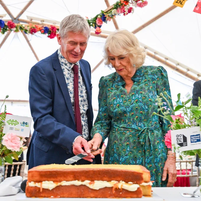 Her Majesty The Queen cutting a marmalade sandwich-inspired cake