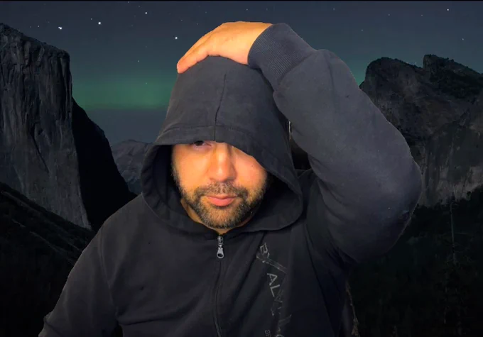 bob in a black hoodie hand on head on a background of stars and northern lights