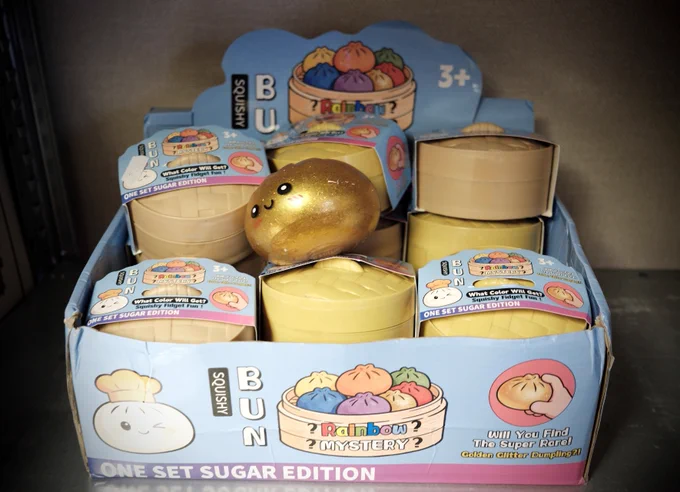 A display box of seized 'Bun Squishy' mystery toys, featuring a golden glittery bun toy on top.