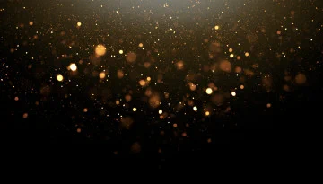 A dark background filled with shimmering golden bokeh lights dispersed throughout the image, creating a sparkling effect.