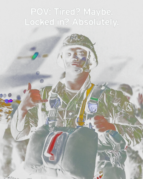 A uniformed Army soldier gives the shaka hand sign. He has equipment strapped to his body and his painted face shows a stoic, confident expression. Text reads, “POV: Tired? Maybe. Locked in? Absolutely.”