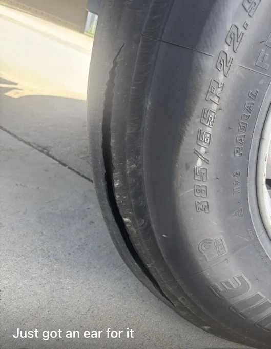 Close-up of a car tire with a severe sidewall bulge indicating a dangerous blowout risk.