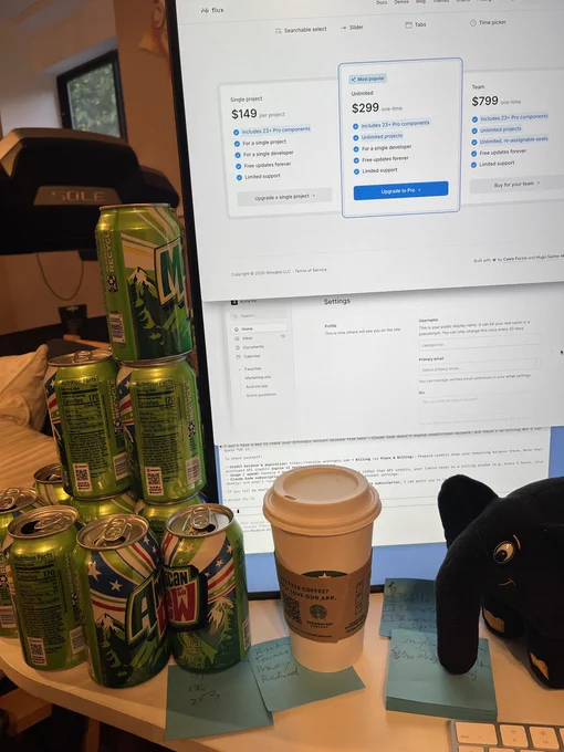 A pile of Mountain Dew cans, a Starbucks coffee, my PHP elephant and my computer screen showing who knows what.