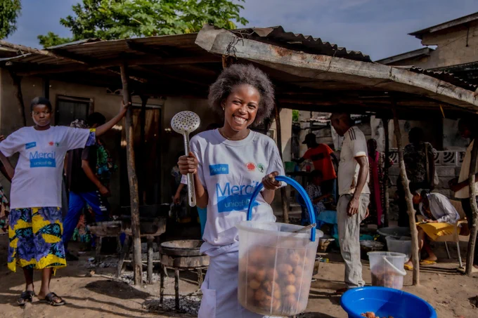 Une adolescente tient un récipient avec des beignets
