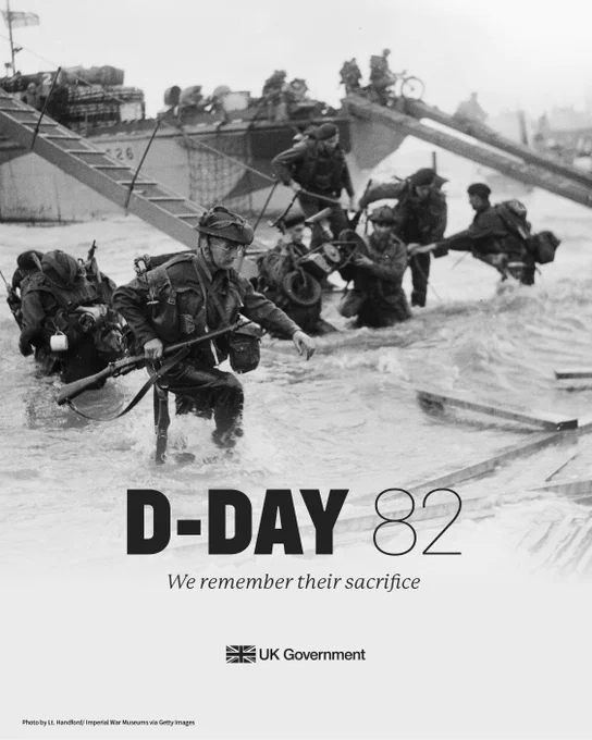 The British 2nd Army: Royal Marine Commandos of Headquarters, 4th Special Service Brigade, making their way from LCI(S)s (Landing Craft Infantry Small) onto 'Nan Red' Beach, JUNO Area, at St Aubin-sur-Mer at about 9 am on, 6 June 1944. Underneath the text reads D-Day 82, we remember their sacrifice.