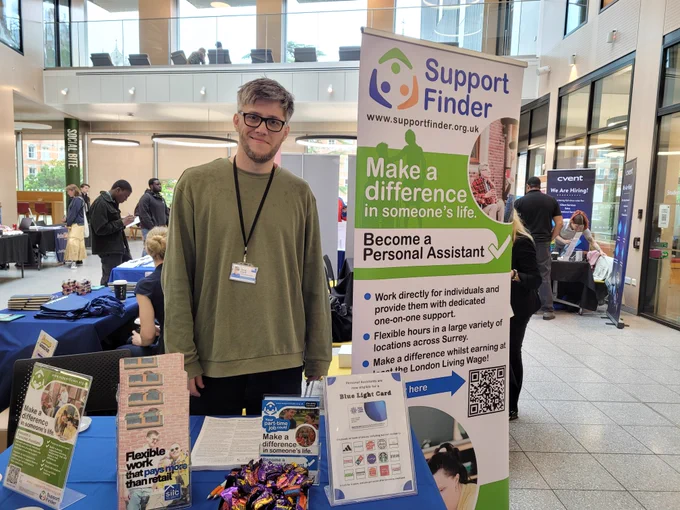 SILC member of staff behind a SILC Support Finder table at the Careers Fair at Royal Holloway.