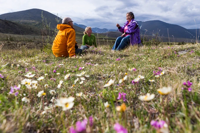 Three people sitting in Ivvavik National Park of Canada in the Yukon Territory. Photo by Parks Canada: Fritz Mueller.