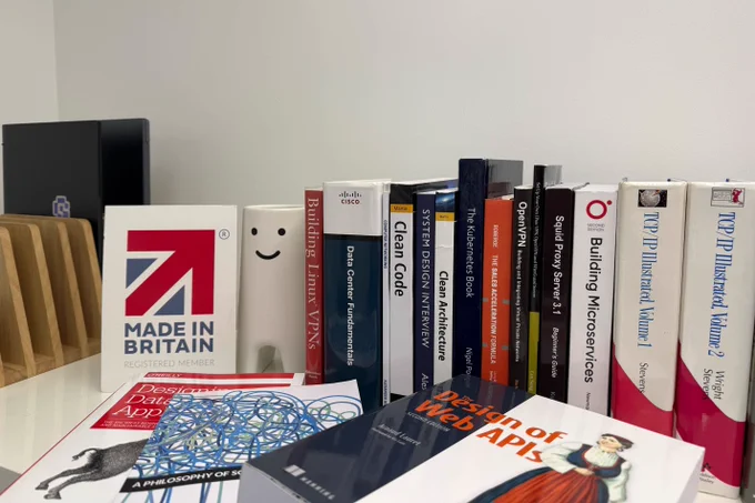A shelf of well-used technical books in Byteful's office, including Clean Code, Clean Architecture, TCP/IP Illustrated, Designing Data-Intensive Applications and Building Microservices.