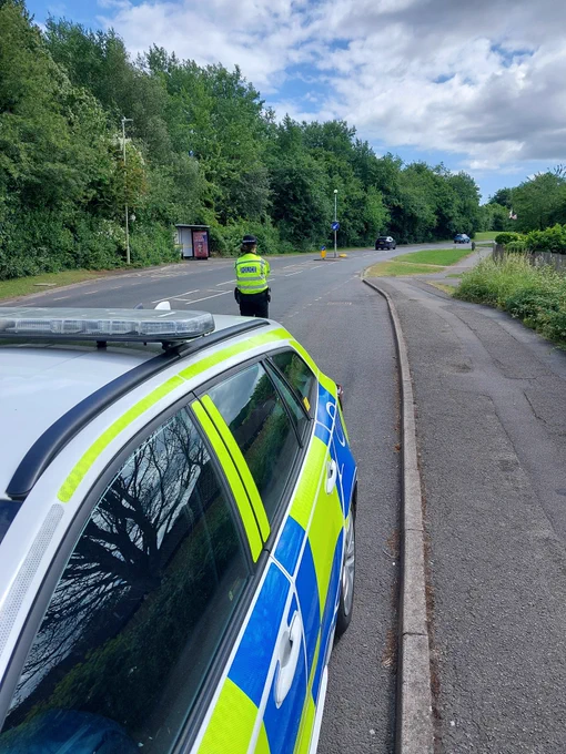 Officer doing speed checks behind marked police vehicle.