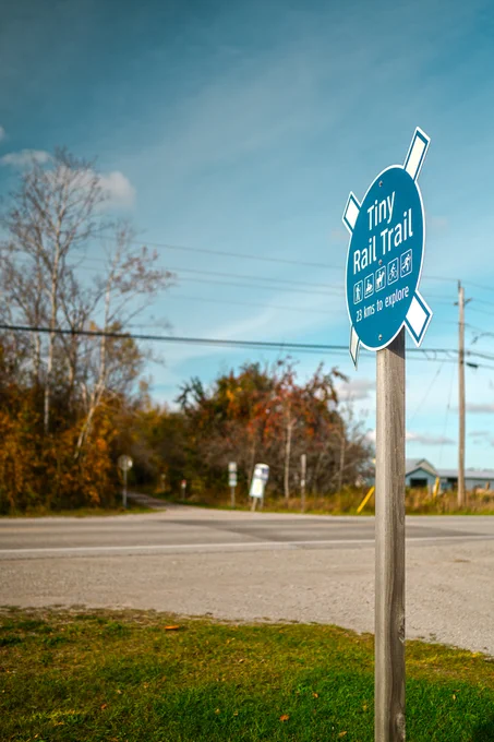 Blue signpost for the Tiny Rail Trail indicating 23 kilometres to explore.