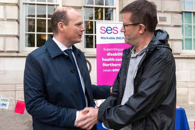 Minister Lyons shaking hands.