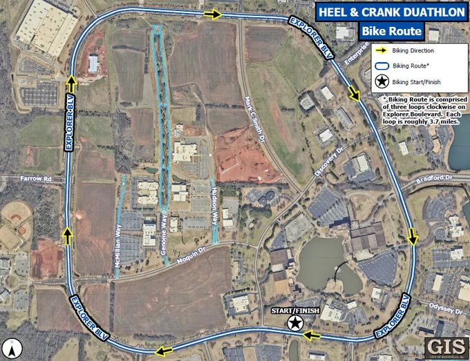 An overhead map shows the Heel & Crank Duathlon bike route. A bold blue line outlines the biking course, which follows a clockwise loop around Explorer Boulevard. Yellow arrows along the route indicate the direction of travel. A black-and-white star near the bottom of the map marks the biking start and finish point. A legend explains the symbols for biking direction, route, and start/finish. A note on the right side states that the route consists of three clockwise loops on Explorer Boulevard, each approximately 3.7 miles. Surrounding the route are labeled roads, office buildings, open fields, and bodies of water. The bottom right corner includes a GIS logo for the City of Huntsville.