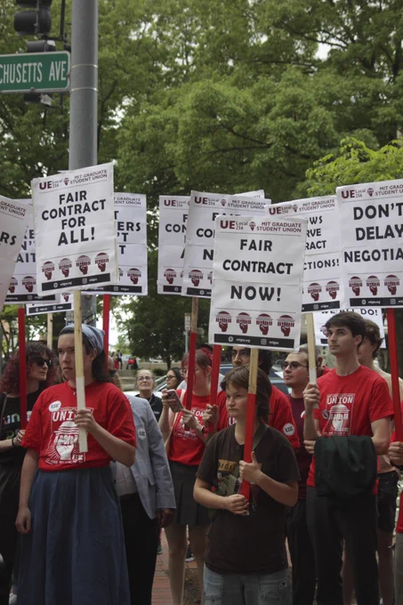 MIT grad workers stand together with picket signs that read “fair contract for all!”