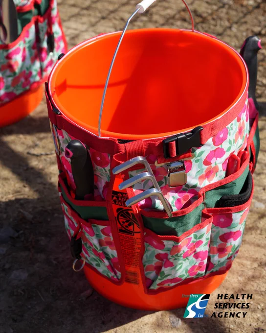 A red gardening bucket.
Un cubo de jardinería rojo.