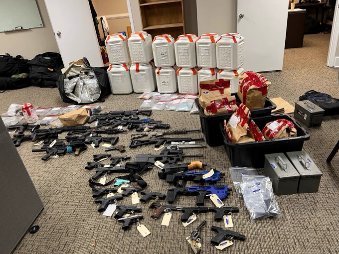 This image shows the items confiscated from Defendant Vincent Simon's home during the execution of a search warrant including drugs and firearms.  