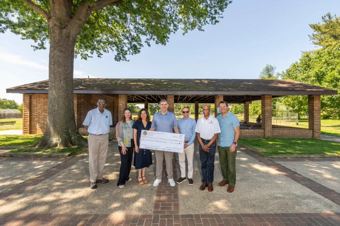 Montgomery Parks leadership with District 18 representatives holding a ceremonial check at Wheaton Forest Local Park.